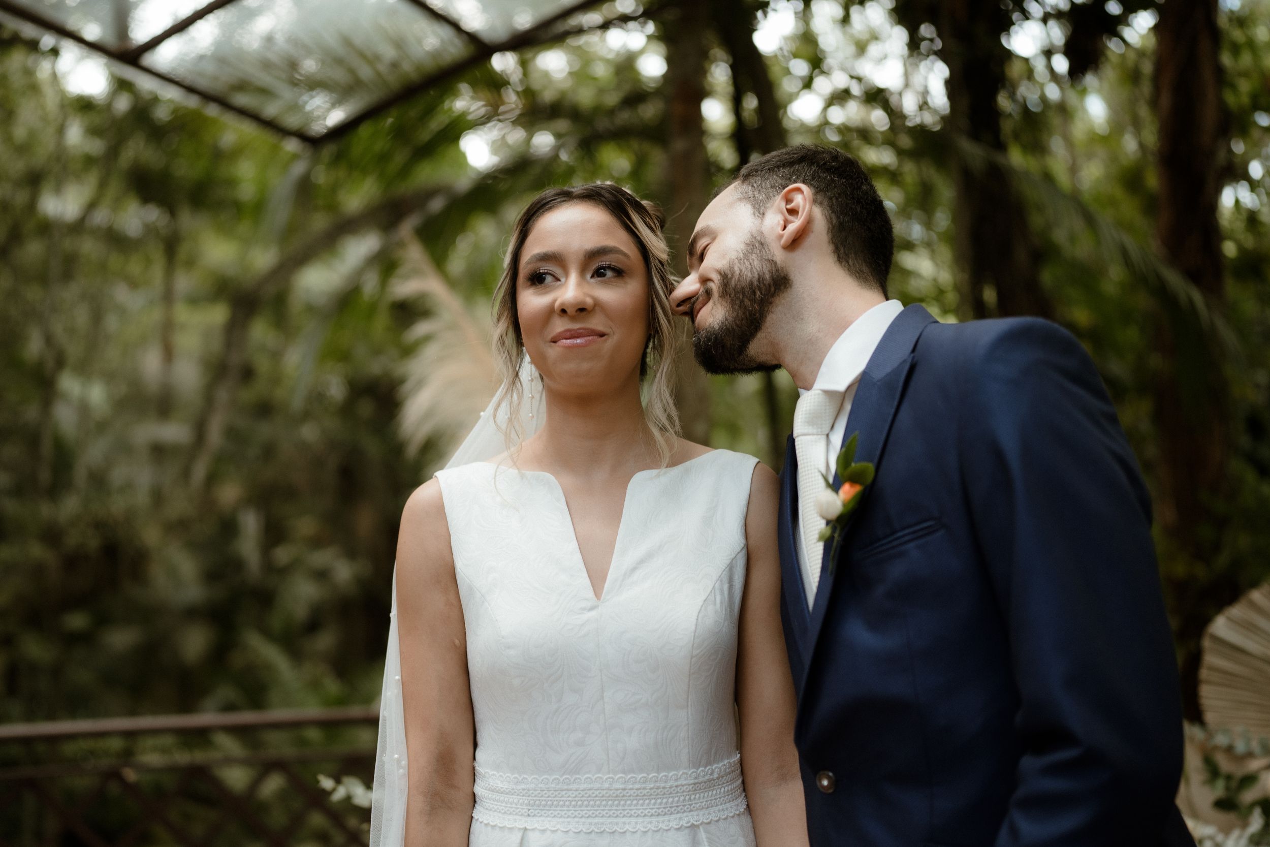 An intimate wedding portrait taken in a natural outdoor setting with soft lighting.