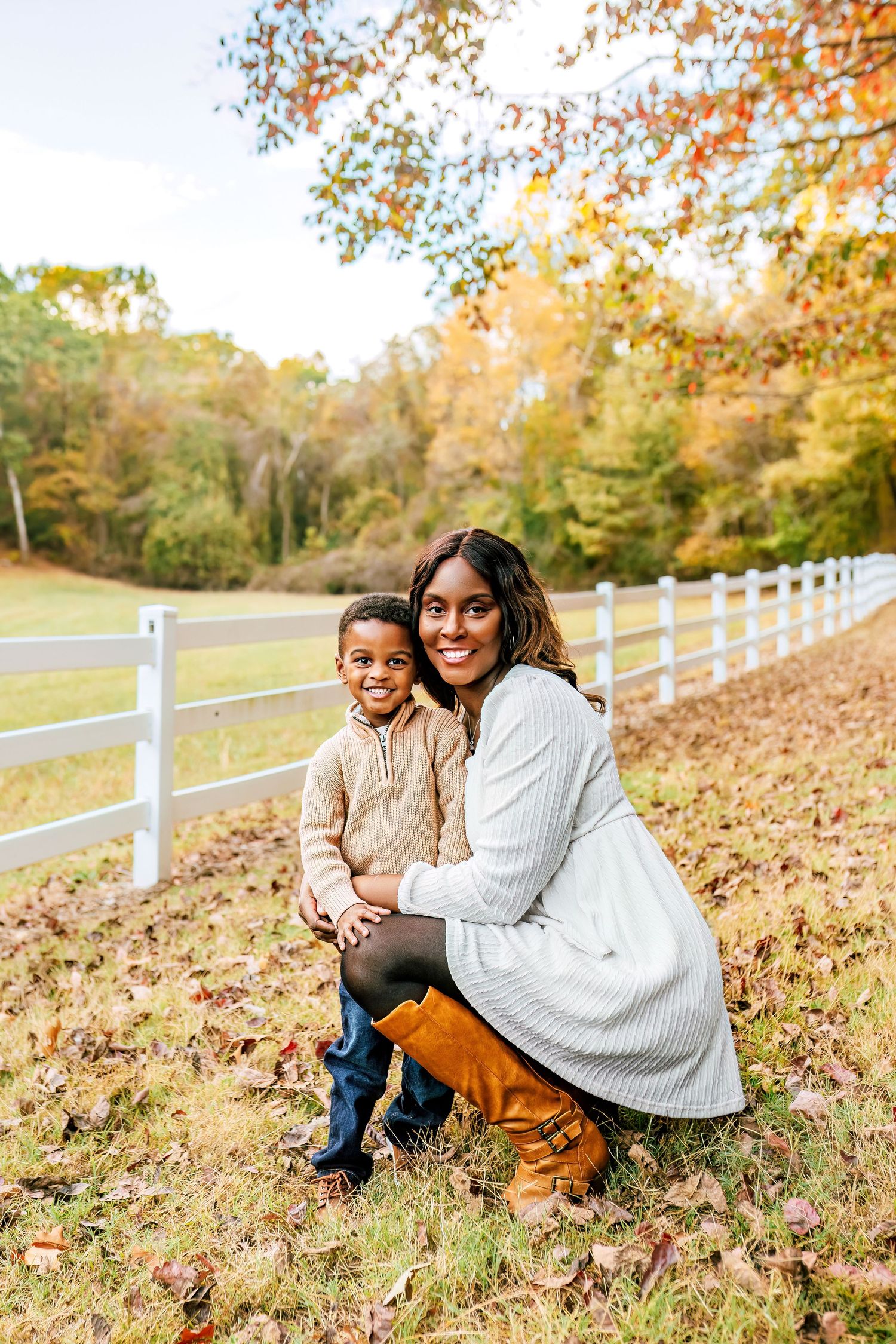 A sweet autumn moment outdoors by white fence with fallen leaves.