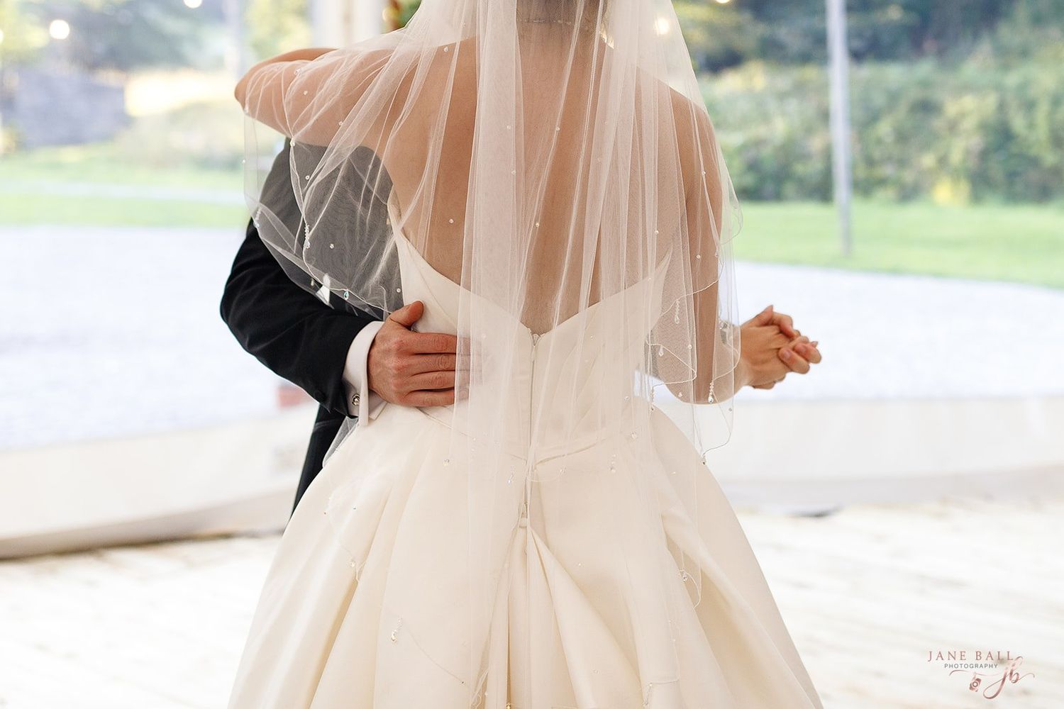 A bride and groom have their first dance in a romantic sail tent at Gisburne Park Estate