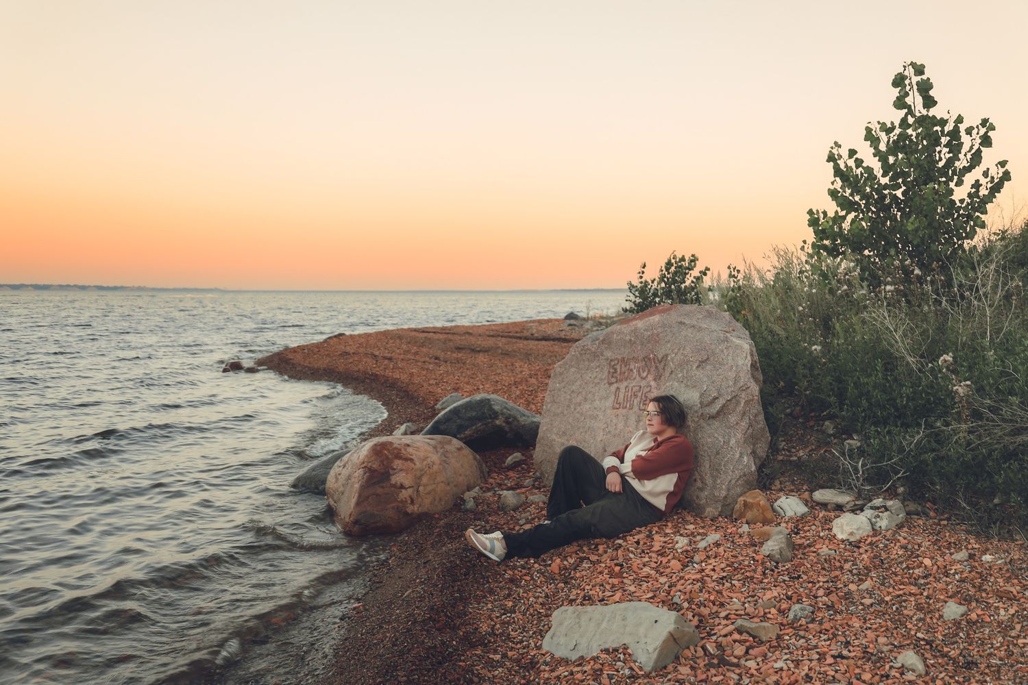 Senior portrait session at Lake Sakakawea near shoreline rocks in Garrison North Dakota senior photography serving Bismarck ND