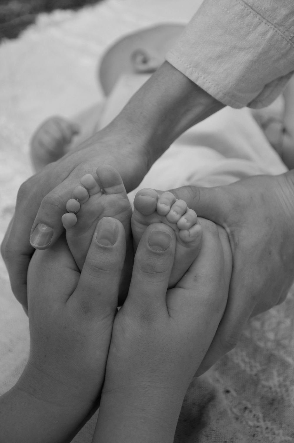 newborn detail photo of mum and dad holding baby's toes