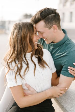 Intimate couple sharing joyful moment against light background.