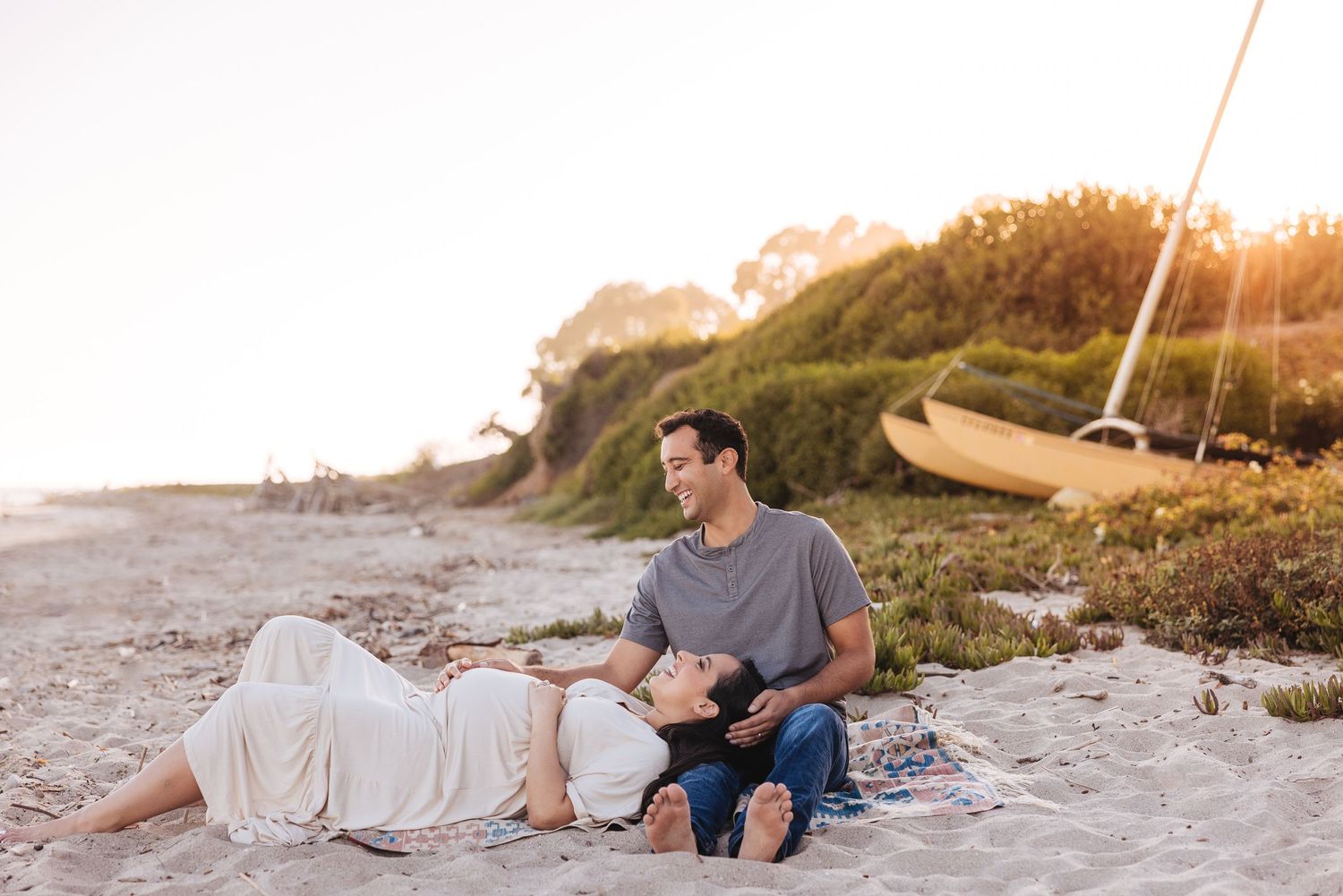 Couple walking along shoreline during sunset beach photography session.