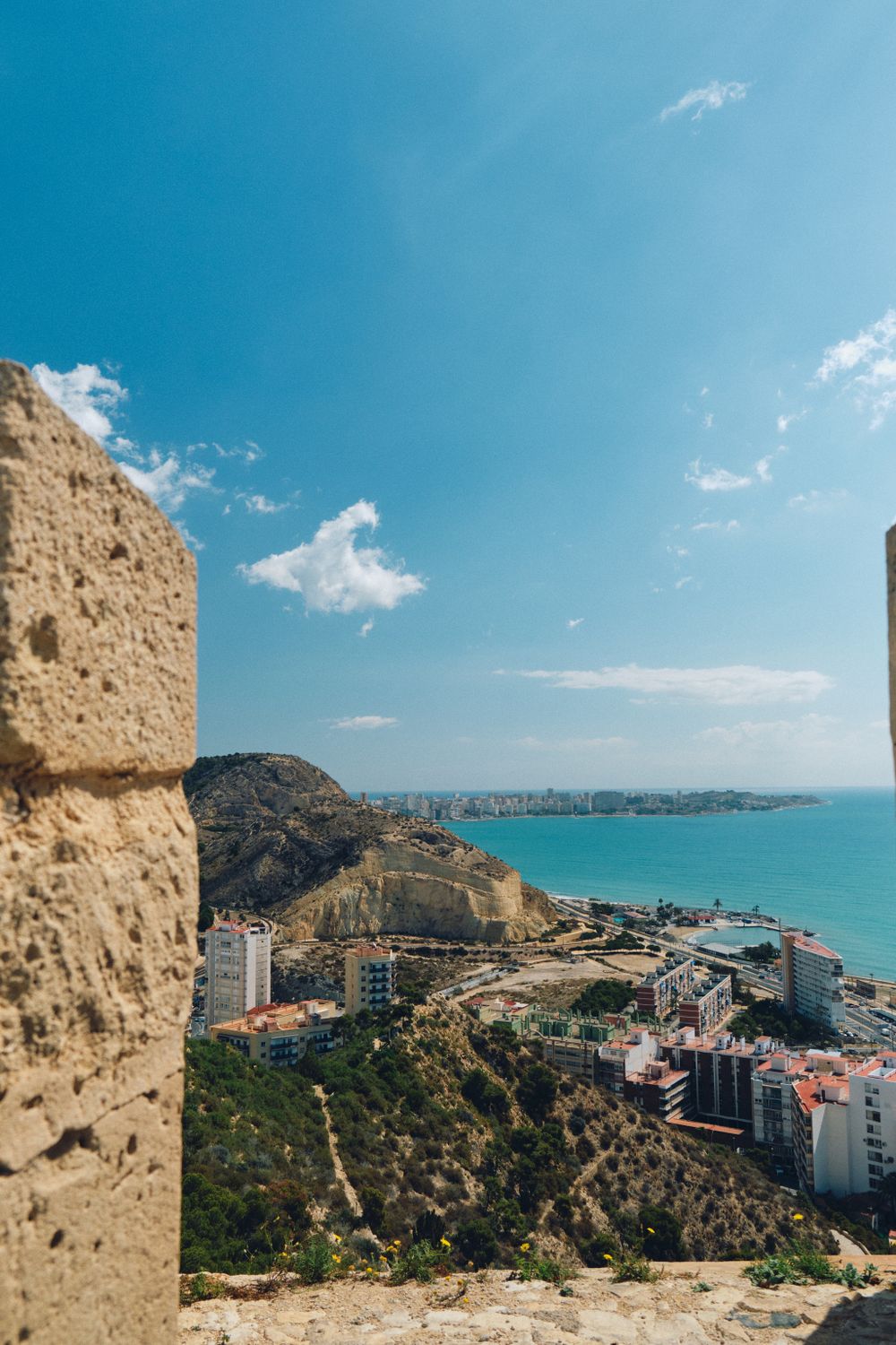 Coastal cityscape view from fortress walls overlooking turquoise Mediterranean Sea.