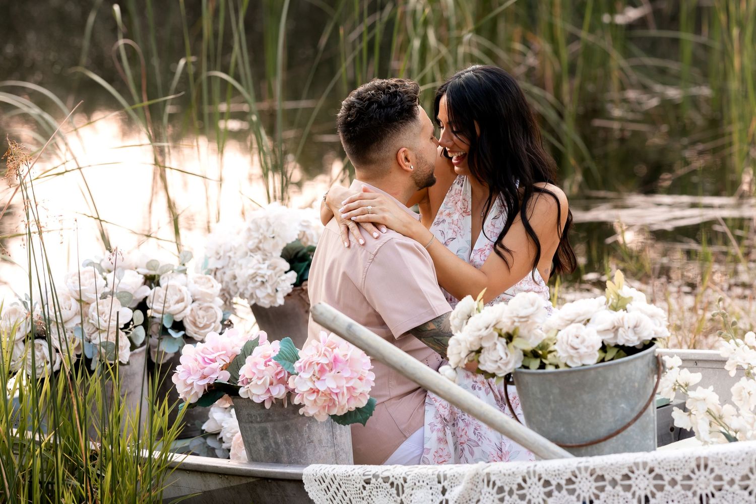 Elegant outdoor wedding photoshoot with couple in white boat among flowers.