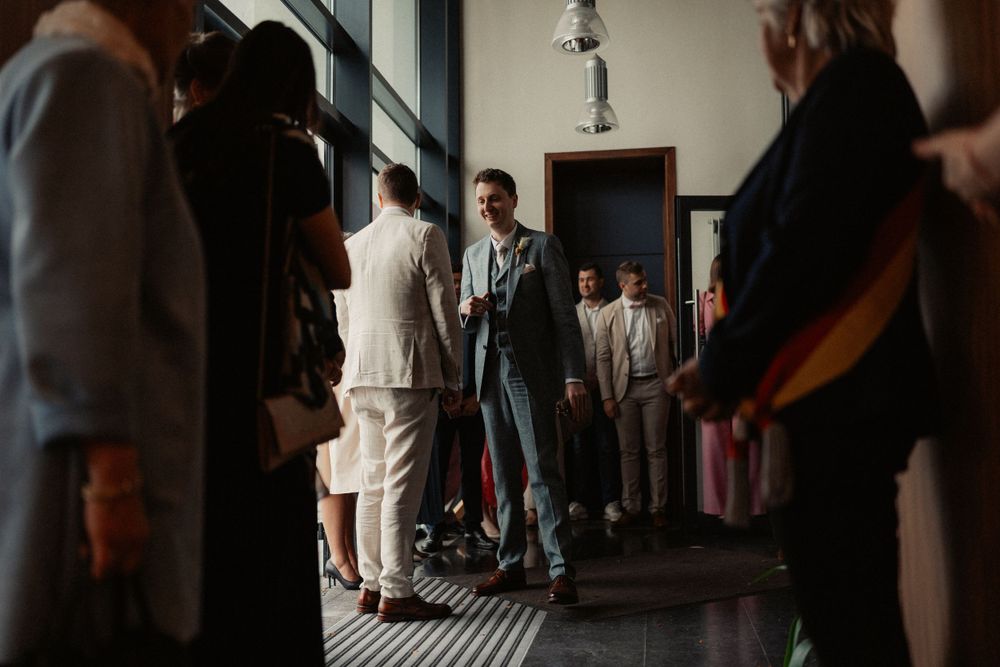 People standing in an elegant hallway with natural light streaming through windows.