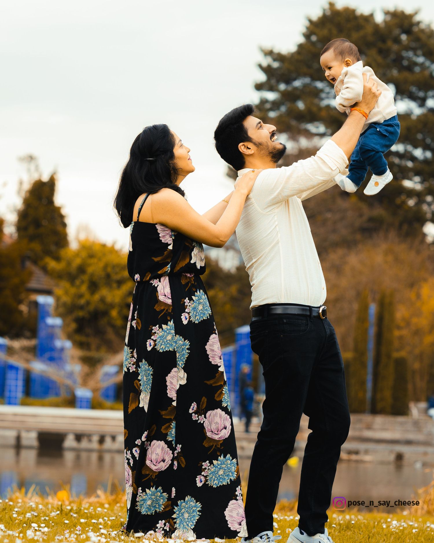 A family enjoying a playful moment in an outdoor park during autumn.