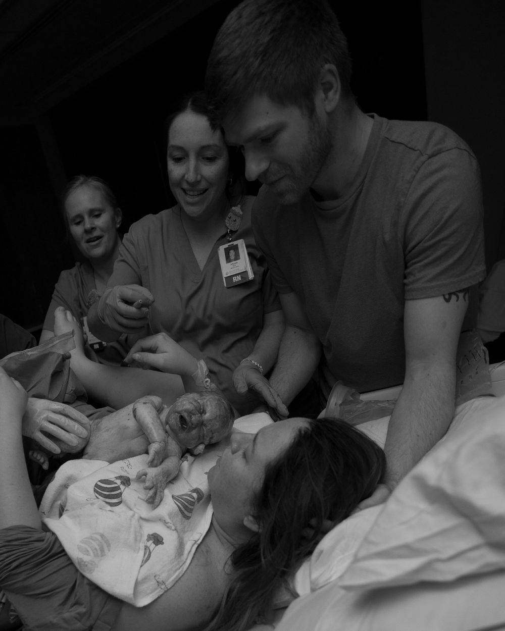 Medical staff and support person gather around patient during labor.
