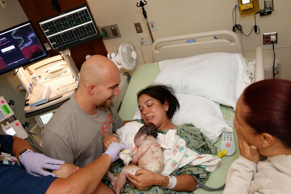 Medical team provides care for newborn in hospital delivery room.