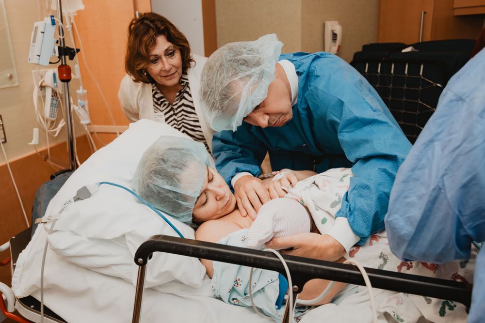 Medical professionals provide care to a patient in a hospital bed while being observed.
