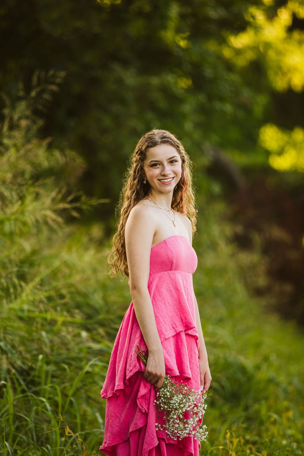 senior session female student pink dress holding flowers