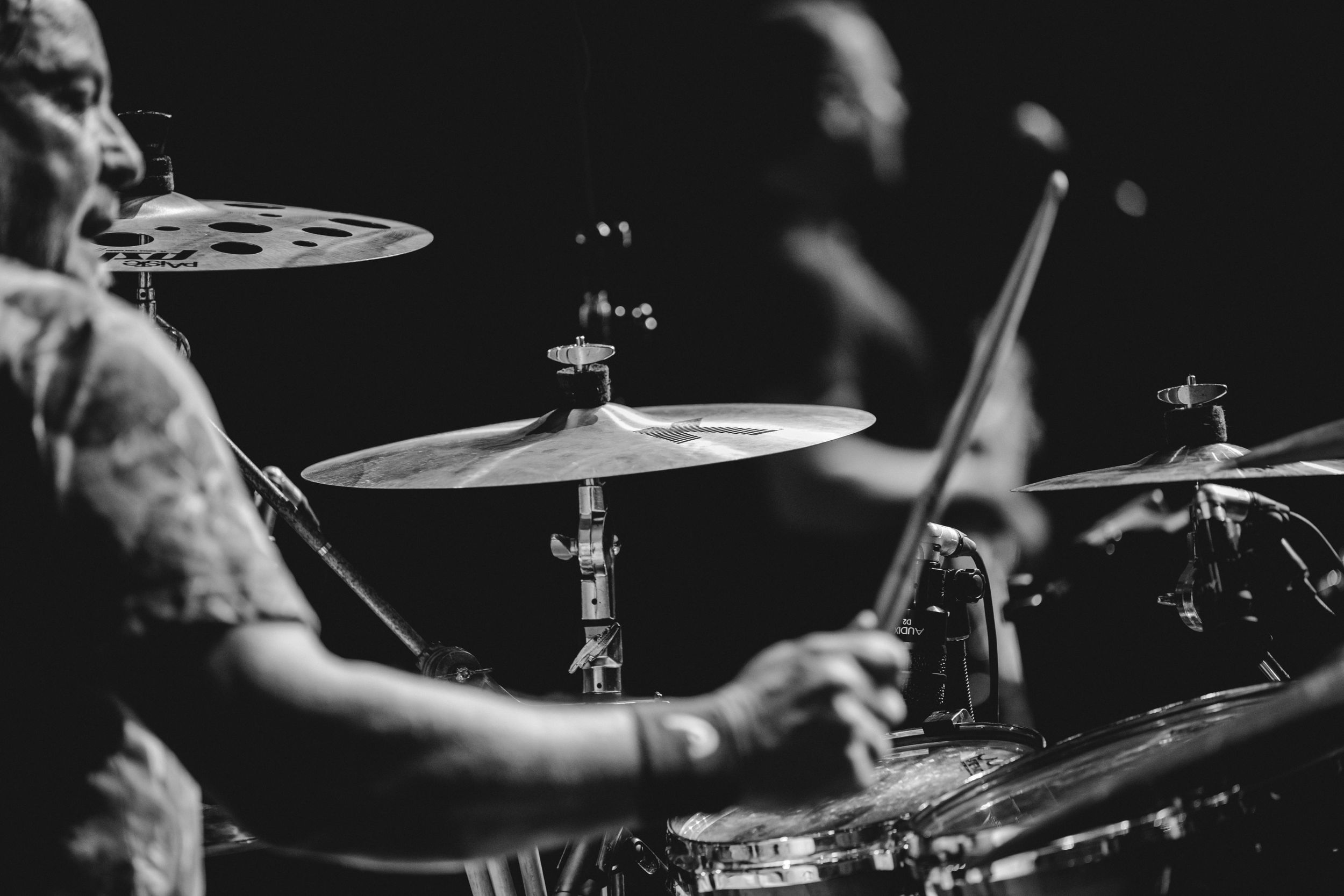 Close-up shot of a drummer playing cymbals during a concert performance.