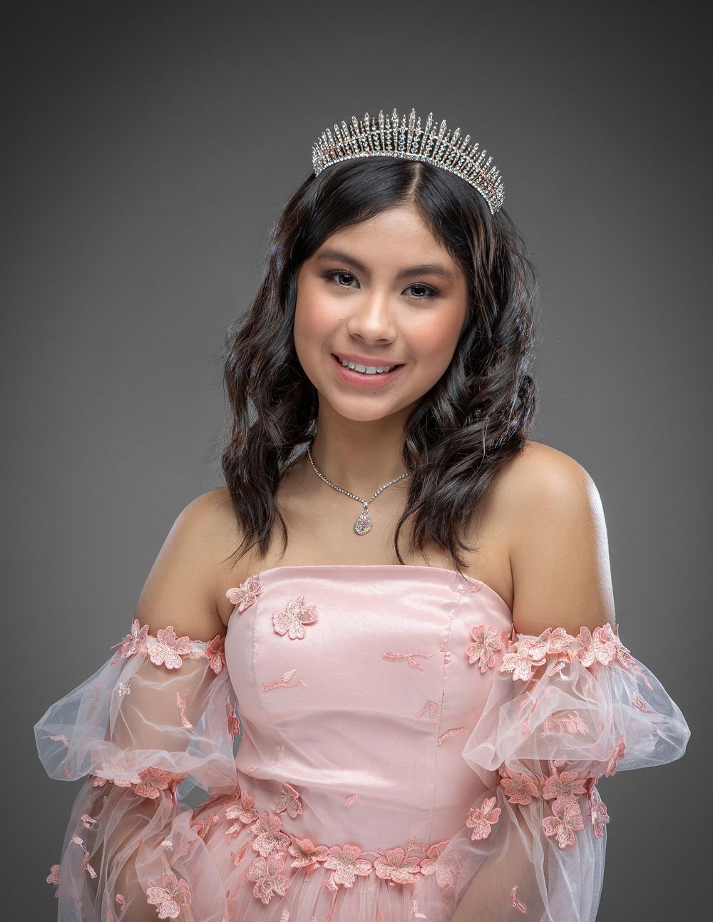 A series of portrait photos showing a person wearing a pink off-shoulder dress and tiara against a gray background.