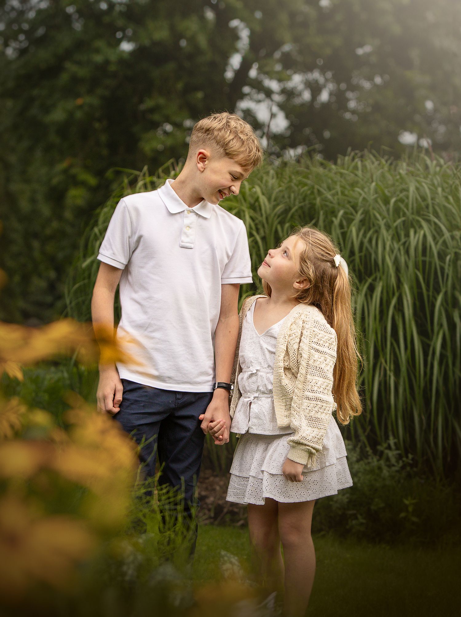 manchester family photographer, siblings at heaton park looking lovingly.