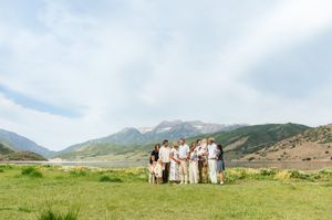 Group photo session with mountains and green fields stretching into the distance.