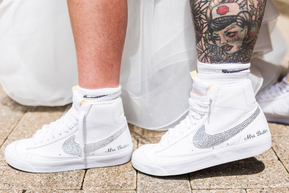 Close-up of wedding Nike Blazer sneakers with rhinestone swoosh and Mrs. title embroidery on white shoes.