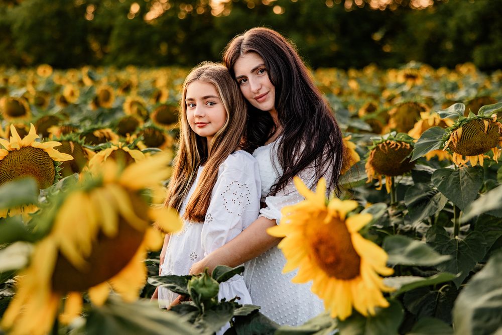 Lifestyle family photography of mom and daughter enjoying sunflowers in Upstate NY.