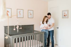 Denver Colorado Newborn Photographer poses family with dog in their newborn's nursery. In home, lifestyle newborn photographer. Candid photo