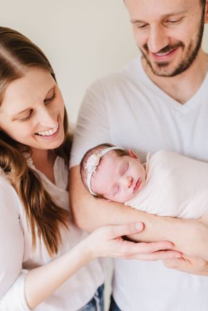 Denver Colorado Newborn Photographer poses family with dog in their newborn's nursery. In home, lifestyle newborn photographer. Candid photo