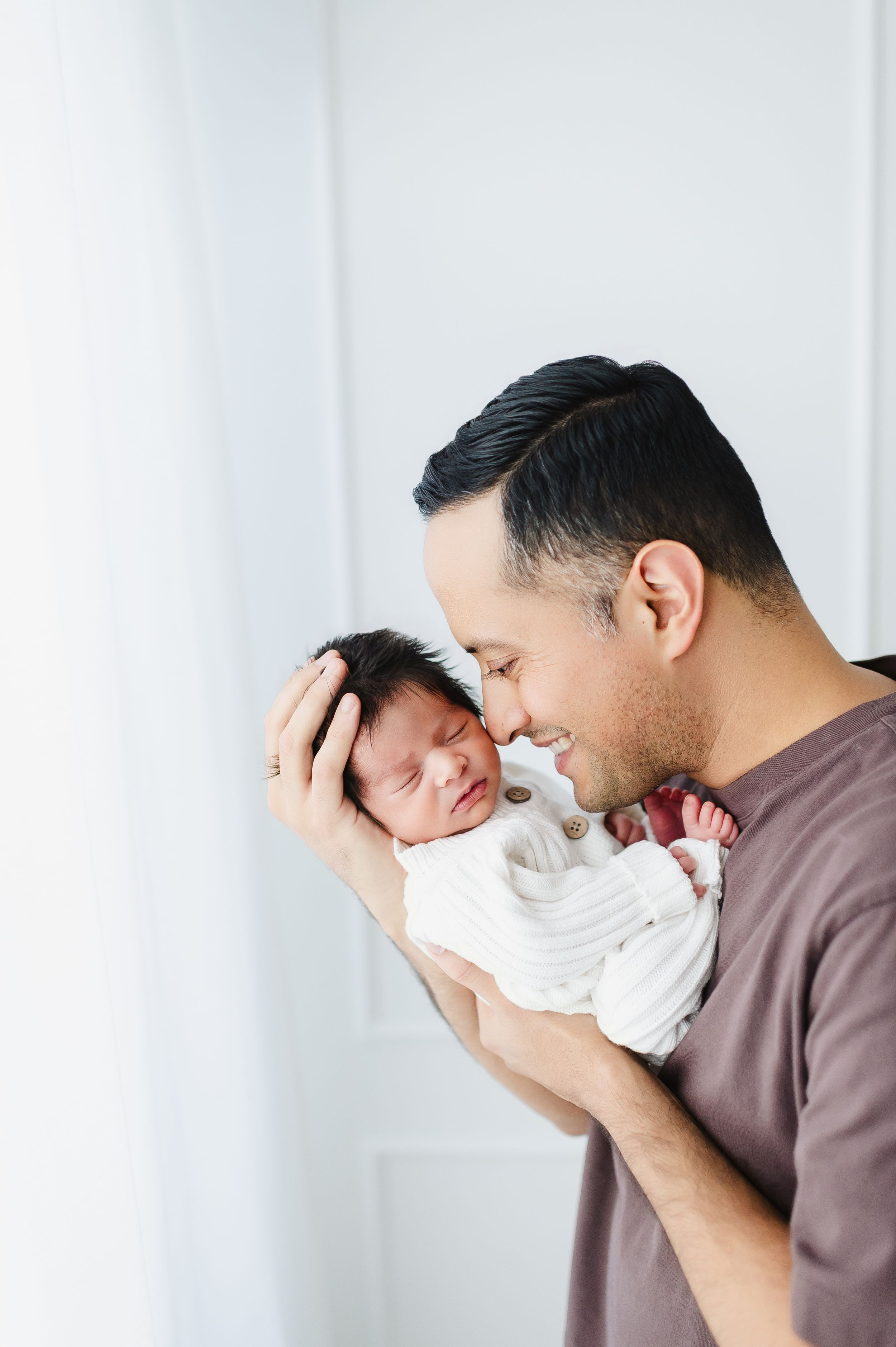 Newborn photography in studio of family and children based in Colorado father and baby cuddling in studio photo session