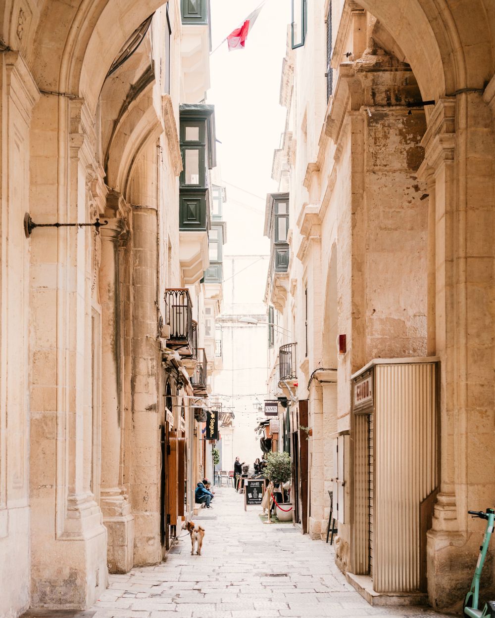 Panoramic view of a historic stone archway corridor with columns and natural light in an ancient Mediterranean city.