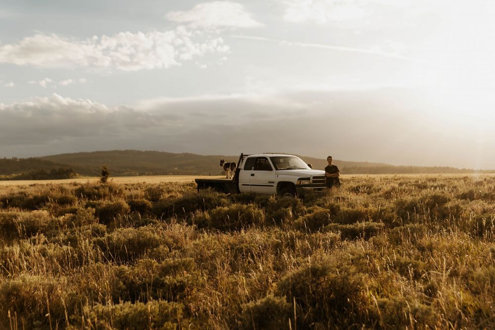 Scenic western landscape with truck and mountains at sunset.