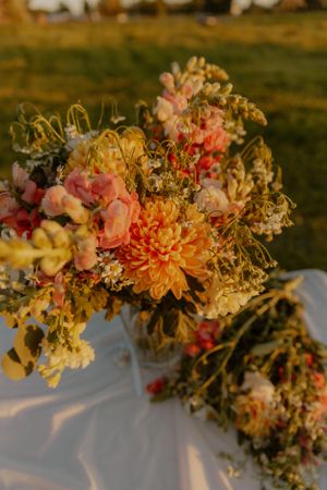Lush floral arrangement with peach and coral blooms creating romantic garden arch.