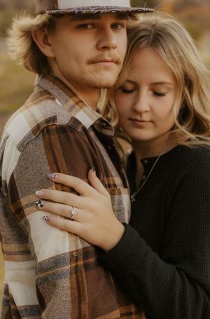 Couple in autumn attire sharing an intimate proposal moment outdoors. Western couple