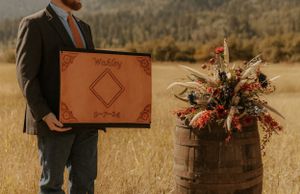 Wedding details in rustic setting with leather accessories and dried flowers.