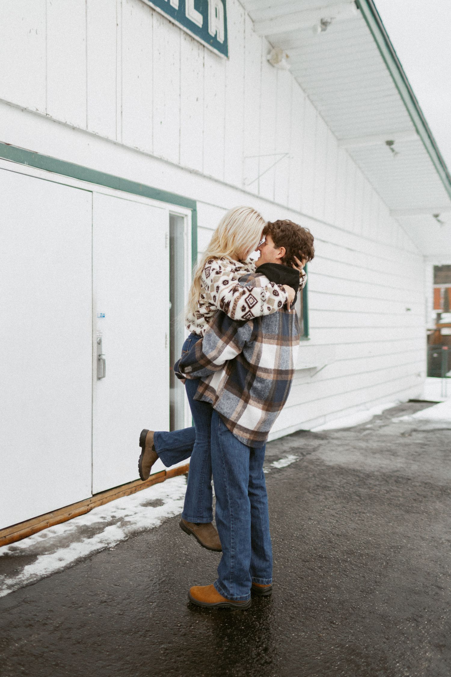 Playful winter engagement photos in the snow with couple having fun outdoors.