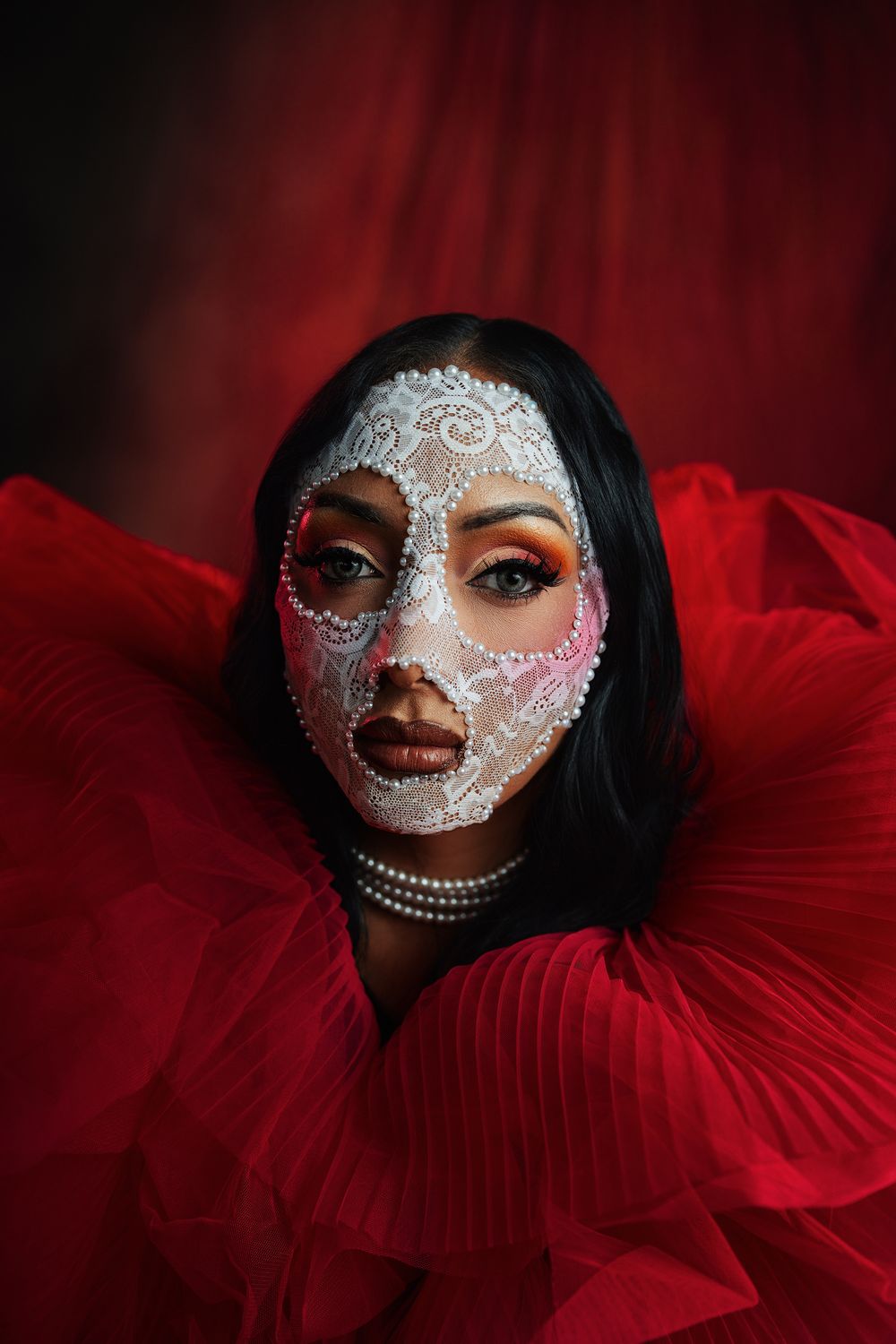 Editorial beauty portrait featuring theatrical makeup, artistic styling, and high-fashion creative design.