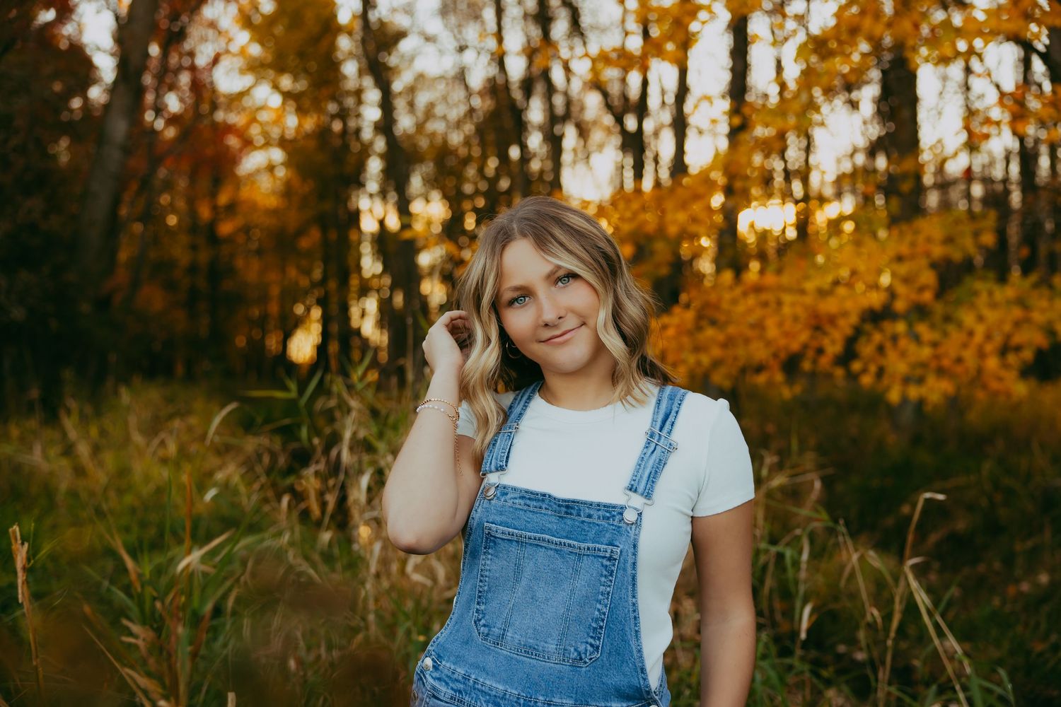 Sunset portrait in wheat field with warm golden lighting.