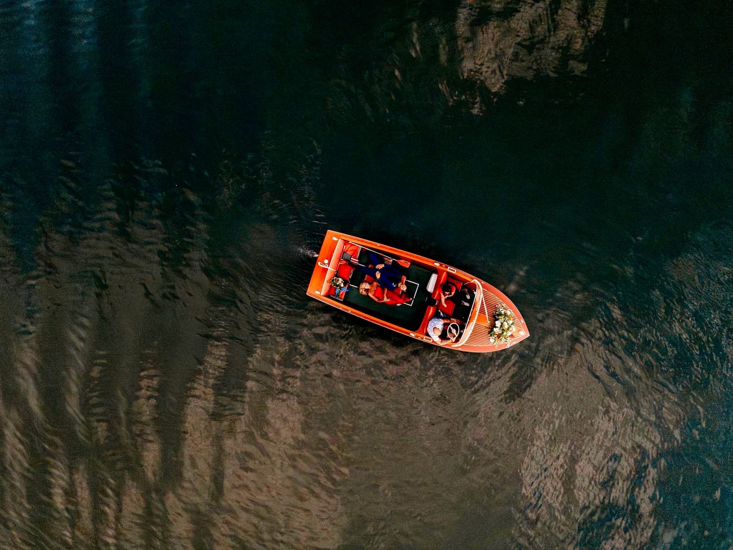 Aerial view of boats navigating dark waters with dramatic contrast and perspective.