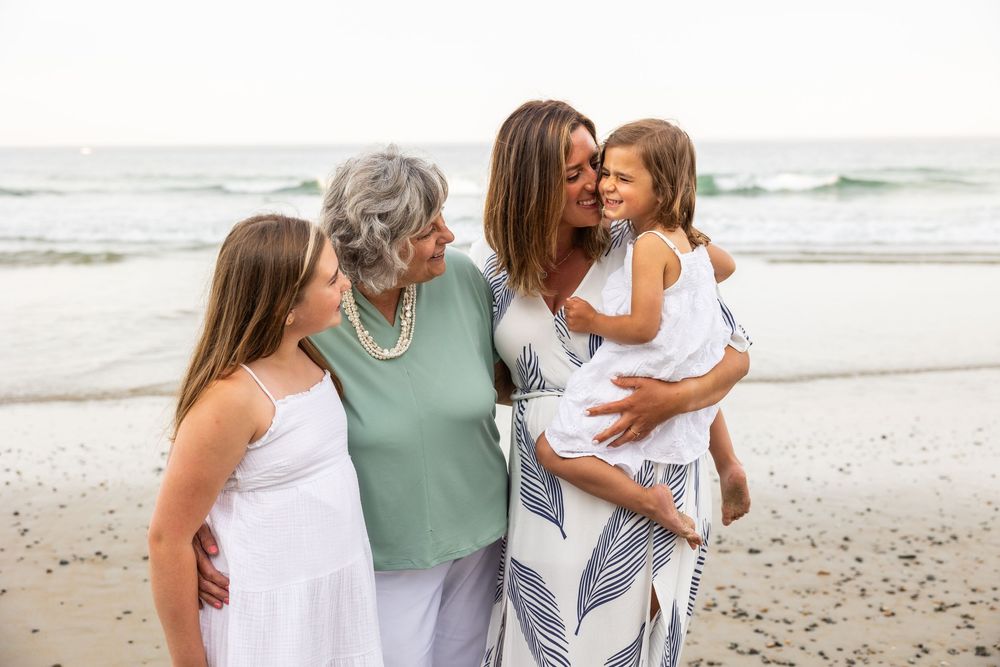 Multi-generational family embracing and walking together on a sunny beach.