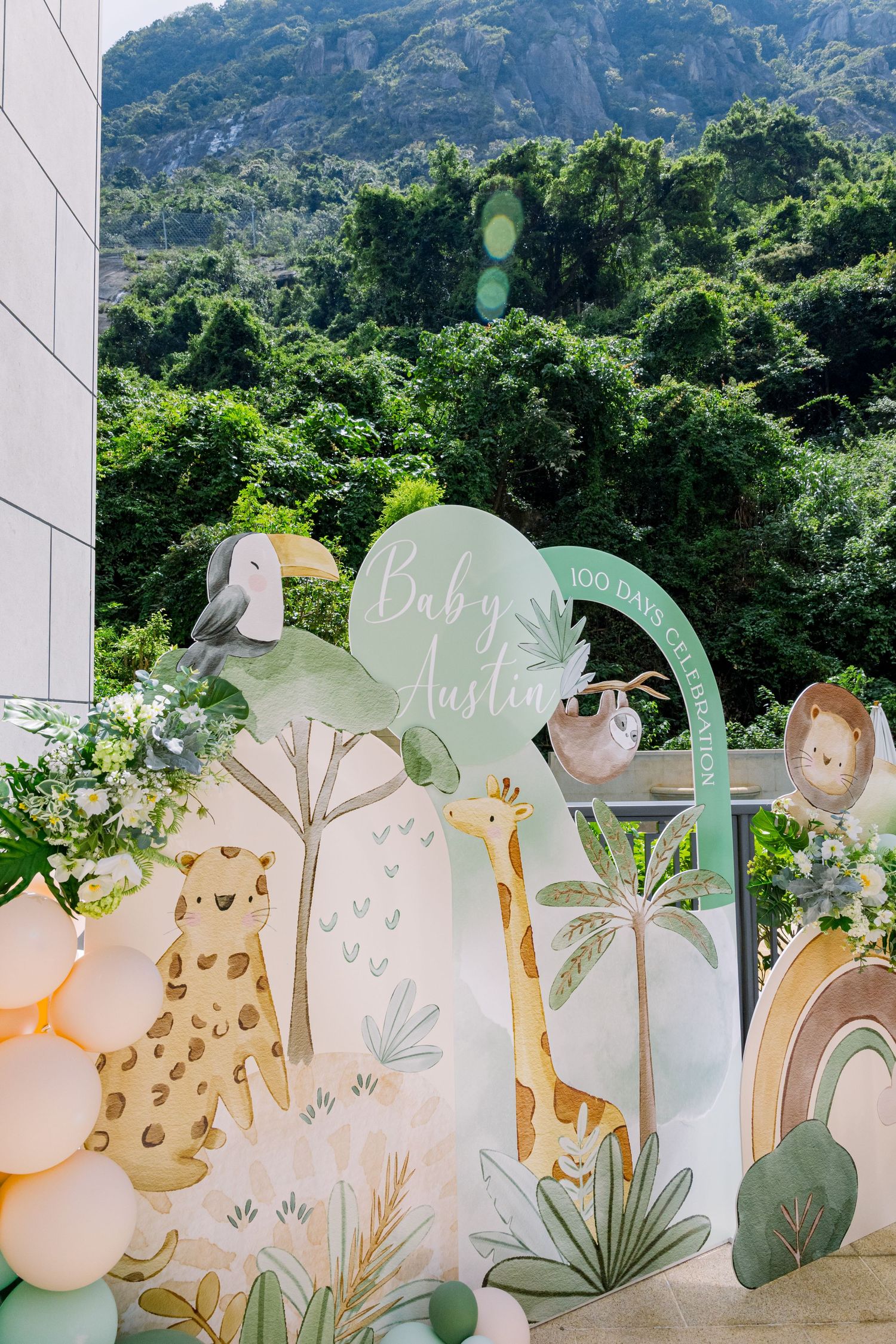 Modern party setup with balloon arch featuring car decor and number 2 in blue and peach colors.