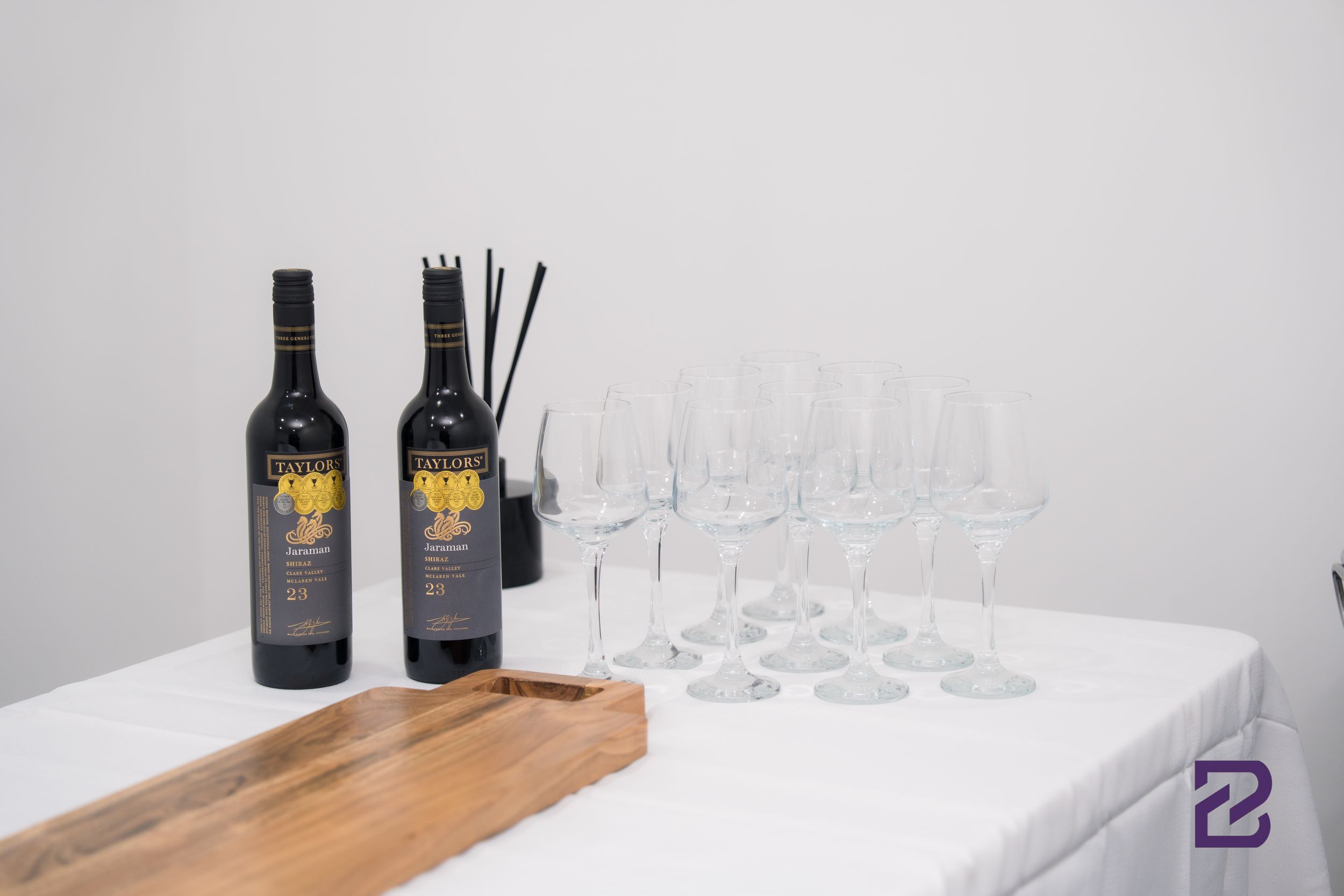 Wine bottles and empty glasses arranged on wooden serving boards for a tasting event.