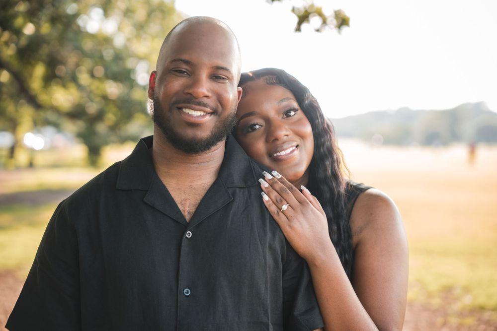 Engaged couple smiling together in golden sunset light.