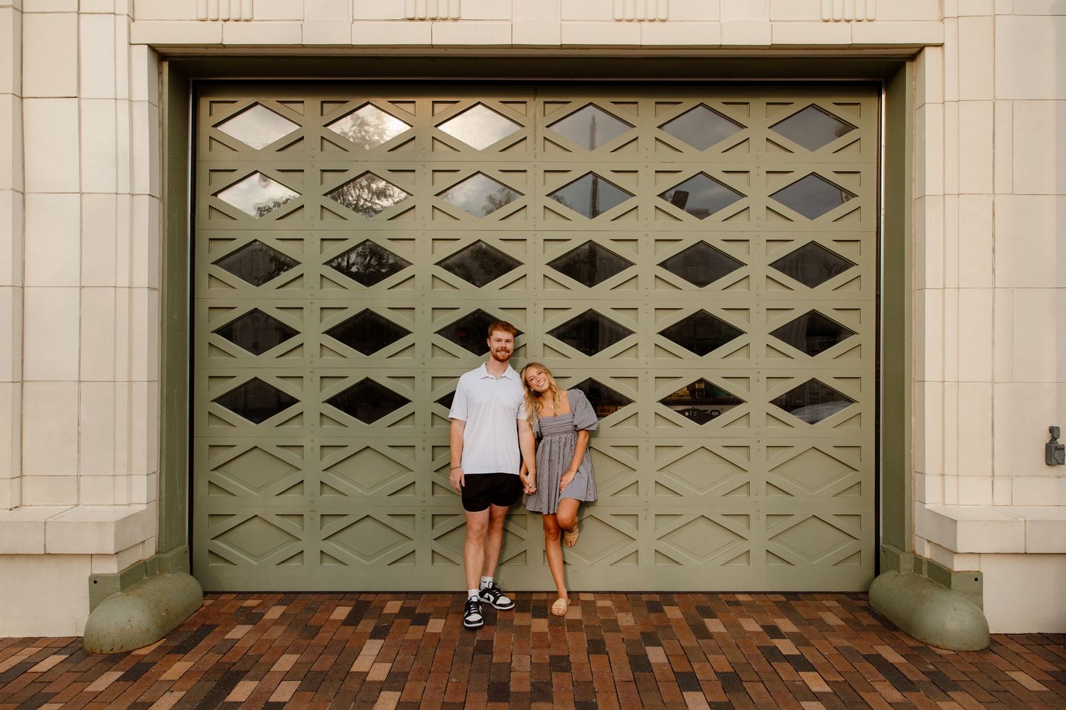 People posing playfully against a vintage geometric garage door.