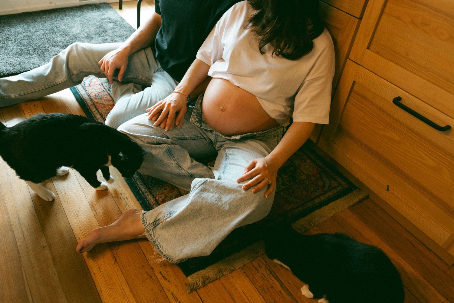 A couple looks at their sonogram under hanging willow branches on a peaceful afternoon.