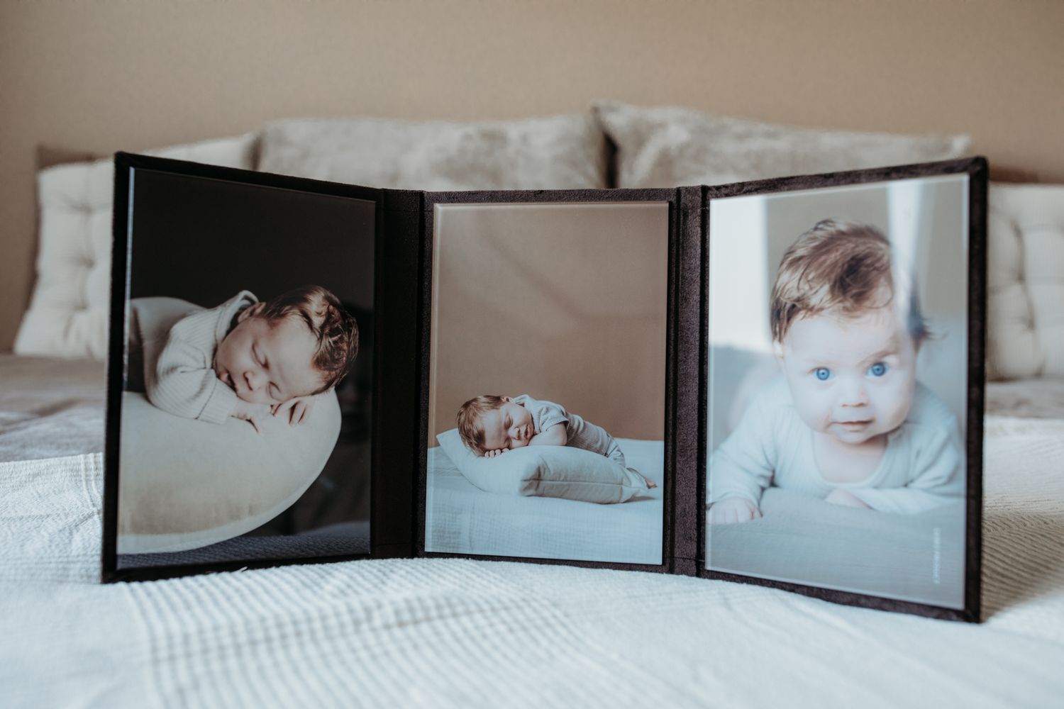 Een triplex. 3 foto's in luiken. Er zijn 3 foto's van een kleine baby te zien.