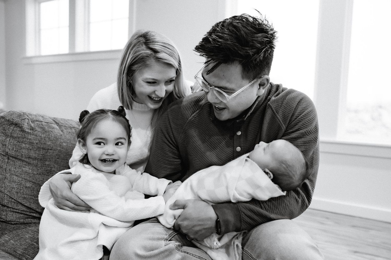 Black and white collage of candid family moments showing laughter and joy in a bright interior setting.