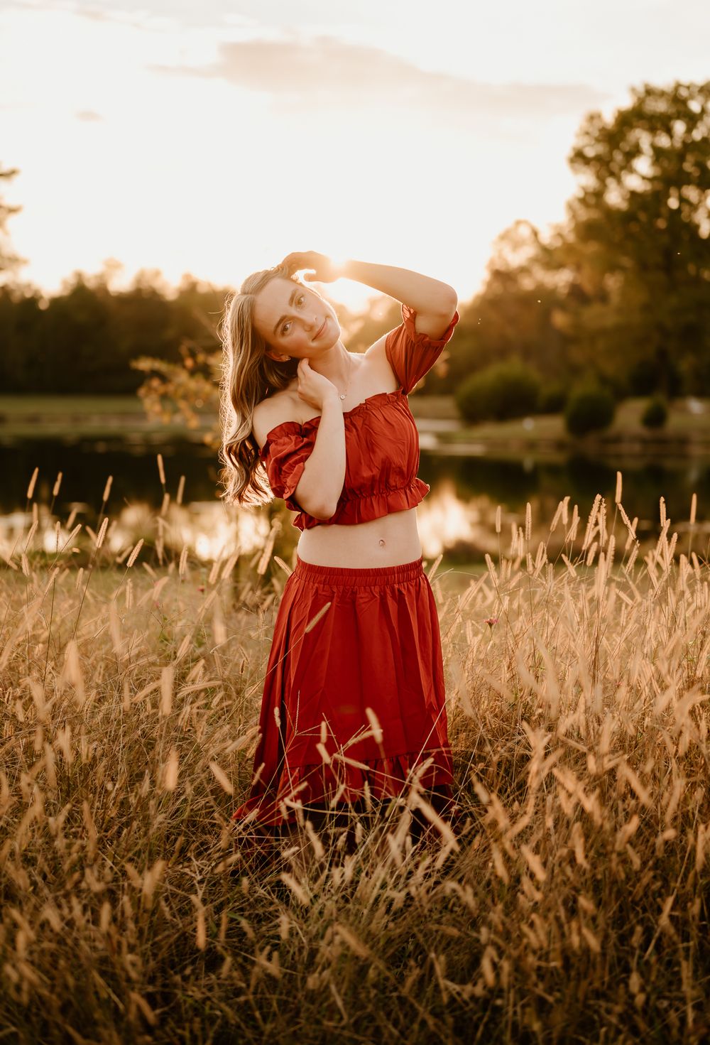 Ethereal sunset scene in a golden wheat field with a figure in a flowing red dress creating a dreamy atmosphere.