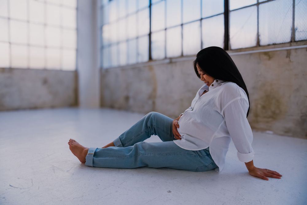 Intimate maternity photo session in bright industrial space.
