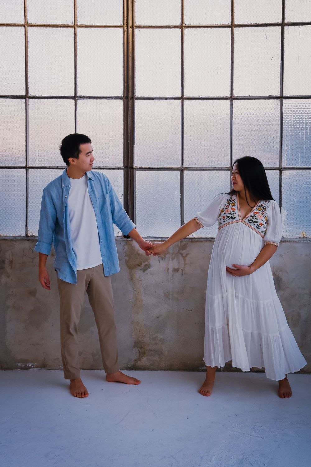 Playful maternity photo sequence with couple in casual attire.