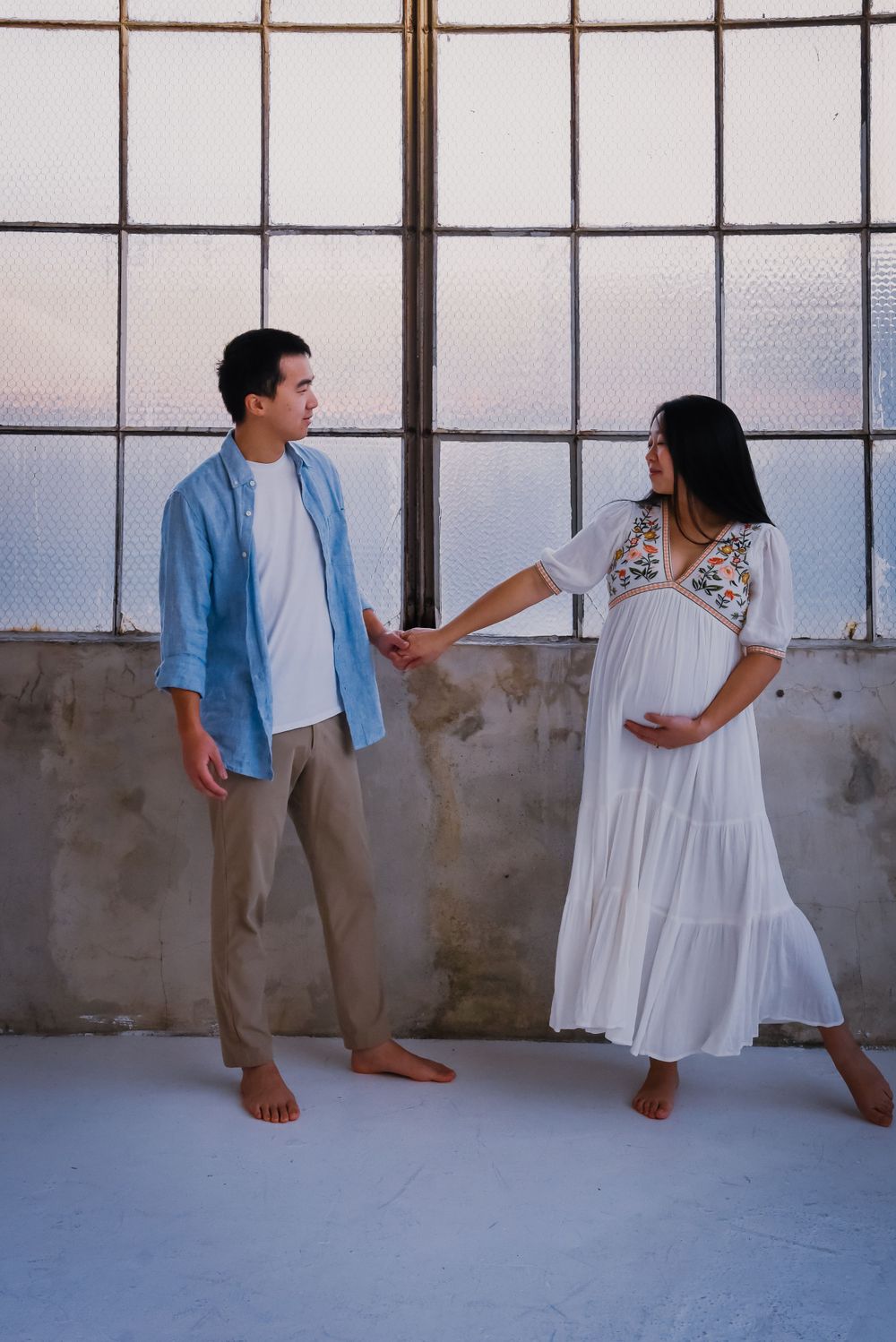 Fun maternity photoshoot showing couple's playful interaction.