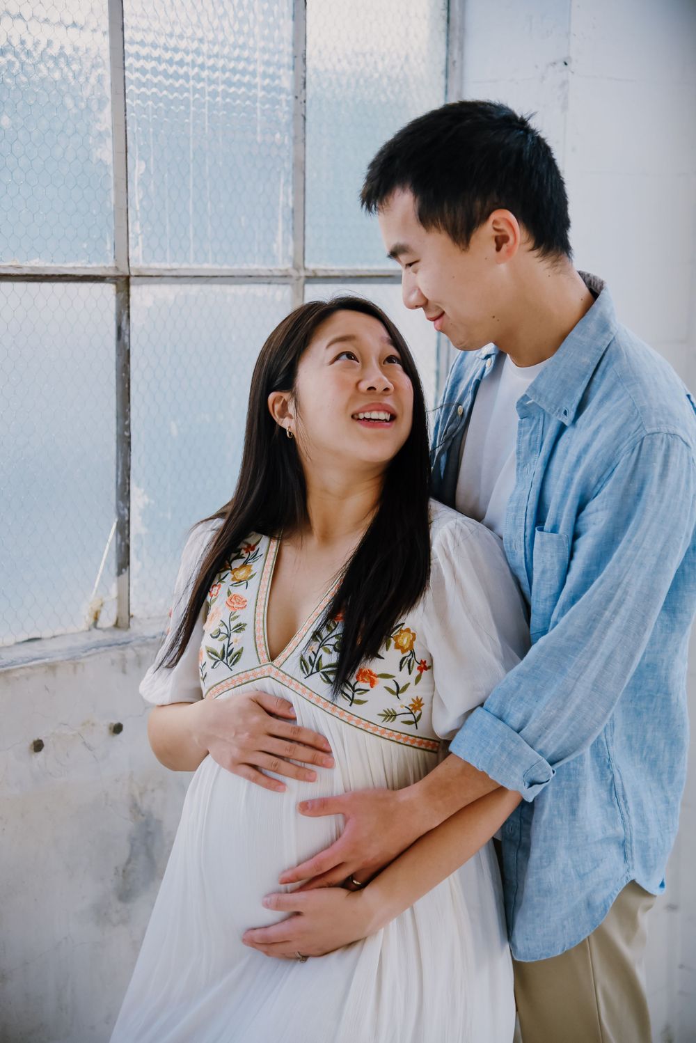 Couple shares tender moment in bright industrial space.