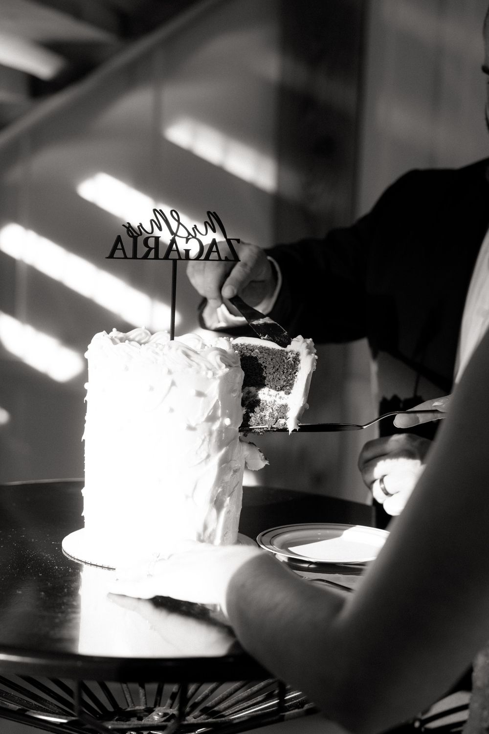 A black and white photo sequence showing someone cutting into a frosted white cake with dramatic lighting and shadows.