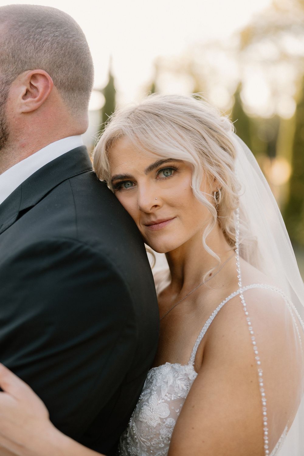 Close-up images of a romantic bride and groom sharing tender moments at a sunset wedding photoshoot.