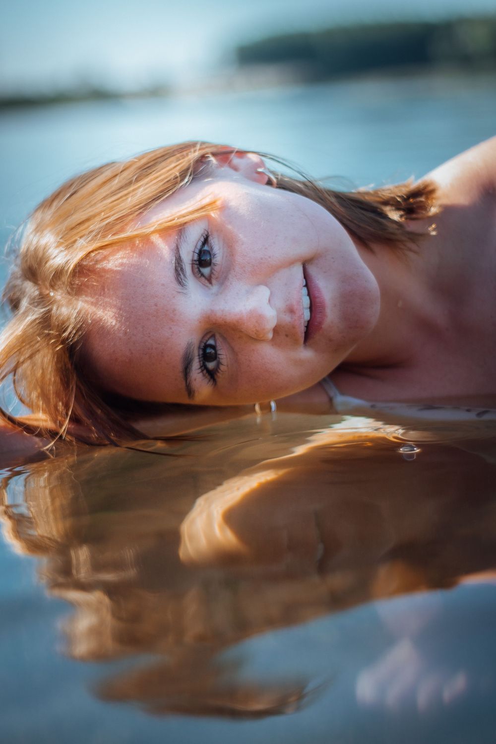 Portrait de Clara dans l'eau, capturé dans une ambiance calme et rafraîchissante, mettant en valeur la fluidité et la beauté naturelle du mo