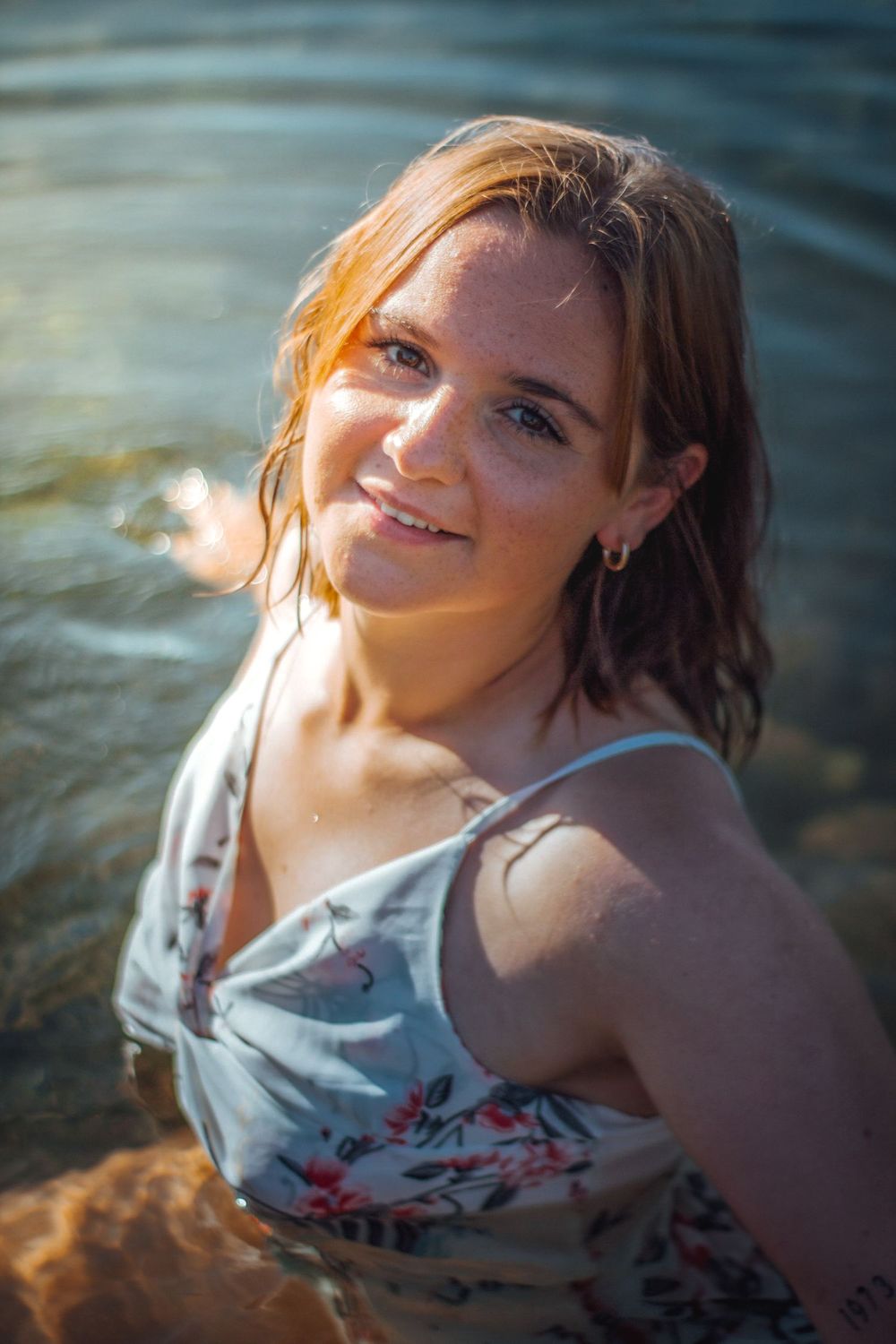 Portrait de Clara dans l'eau, capturé dans une ambiance calme et rafraîchissante, mettant en valeur la fluidité et la beauté naturelle du mo
